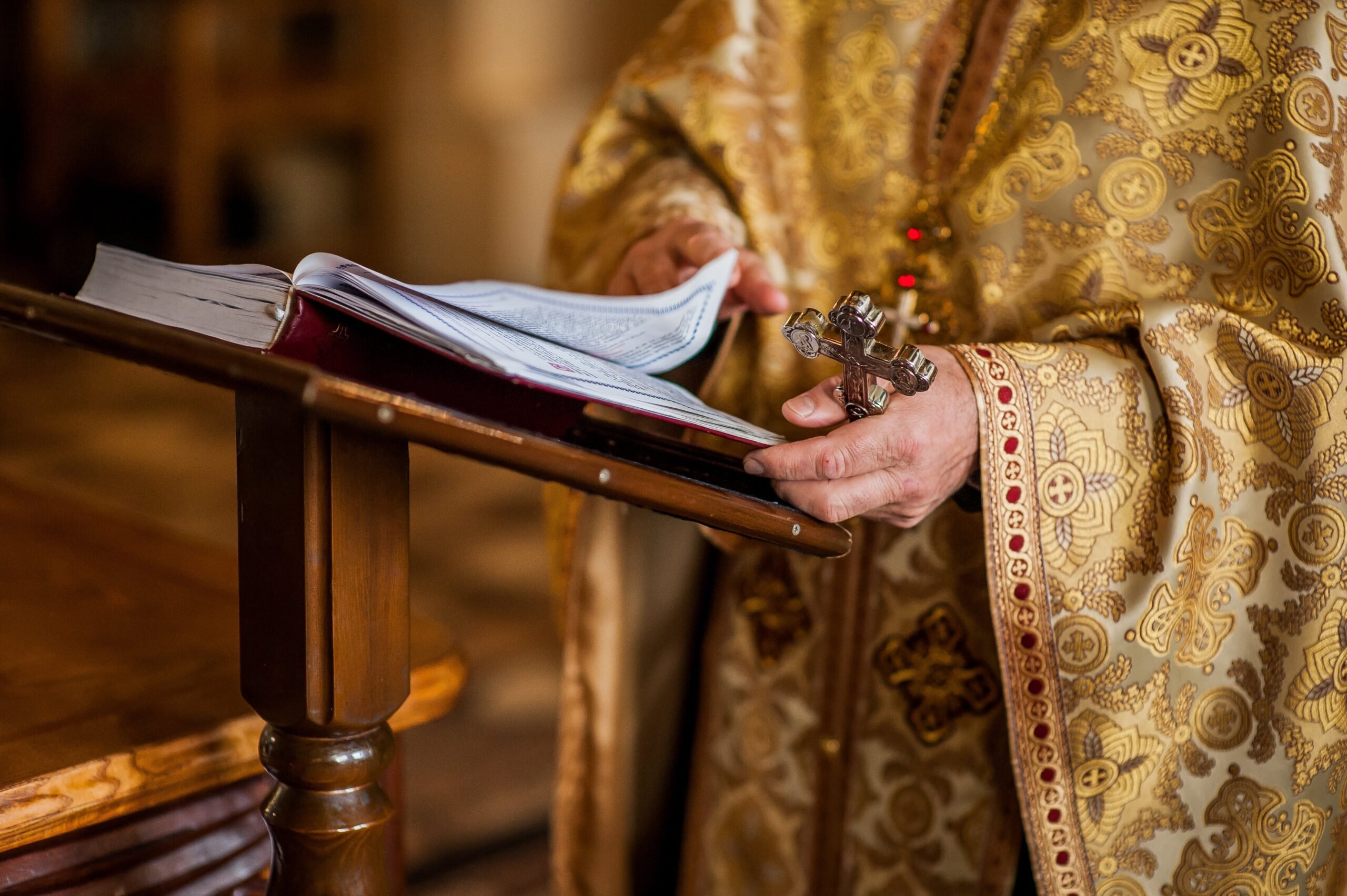 Santa cruz ortodoxa griega con biblia leída por el sacerdote durante el bautismo